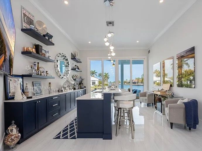 Bright modern kitchen with navy cabinets, white island, and ocean-view windows at CRAFTED 1111 fashion