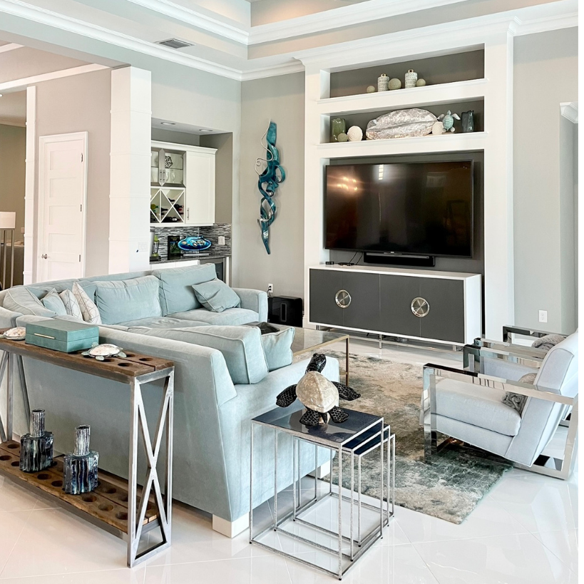 Bright modern living room with light blue sofas, TV, white shelves, and decorative accents at CRAFTED 1111 fashion