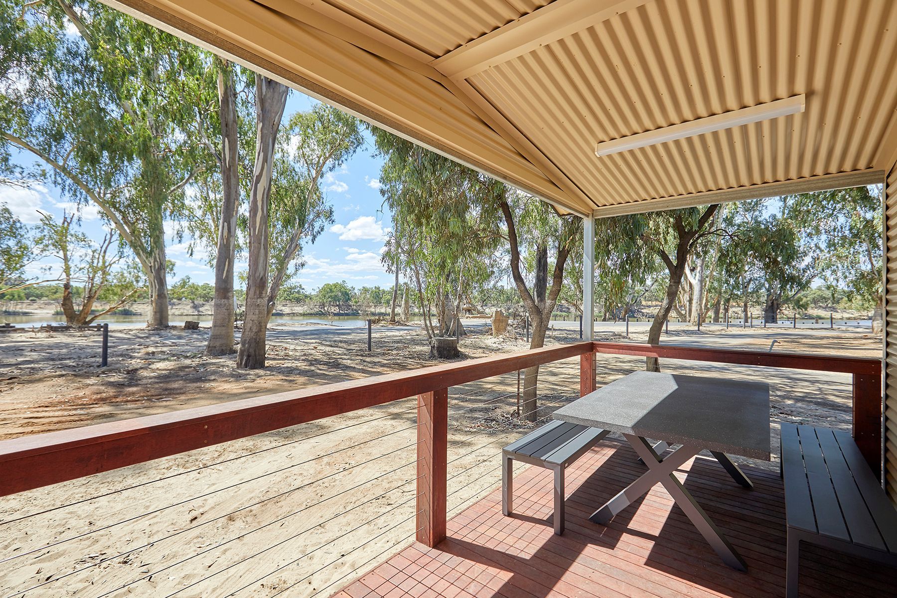 Apex Riverbeach Holiday Park Cabin wooden deck with alfresco dining chairs and table