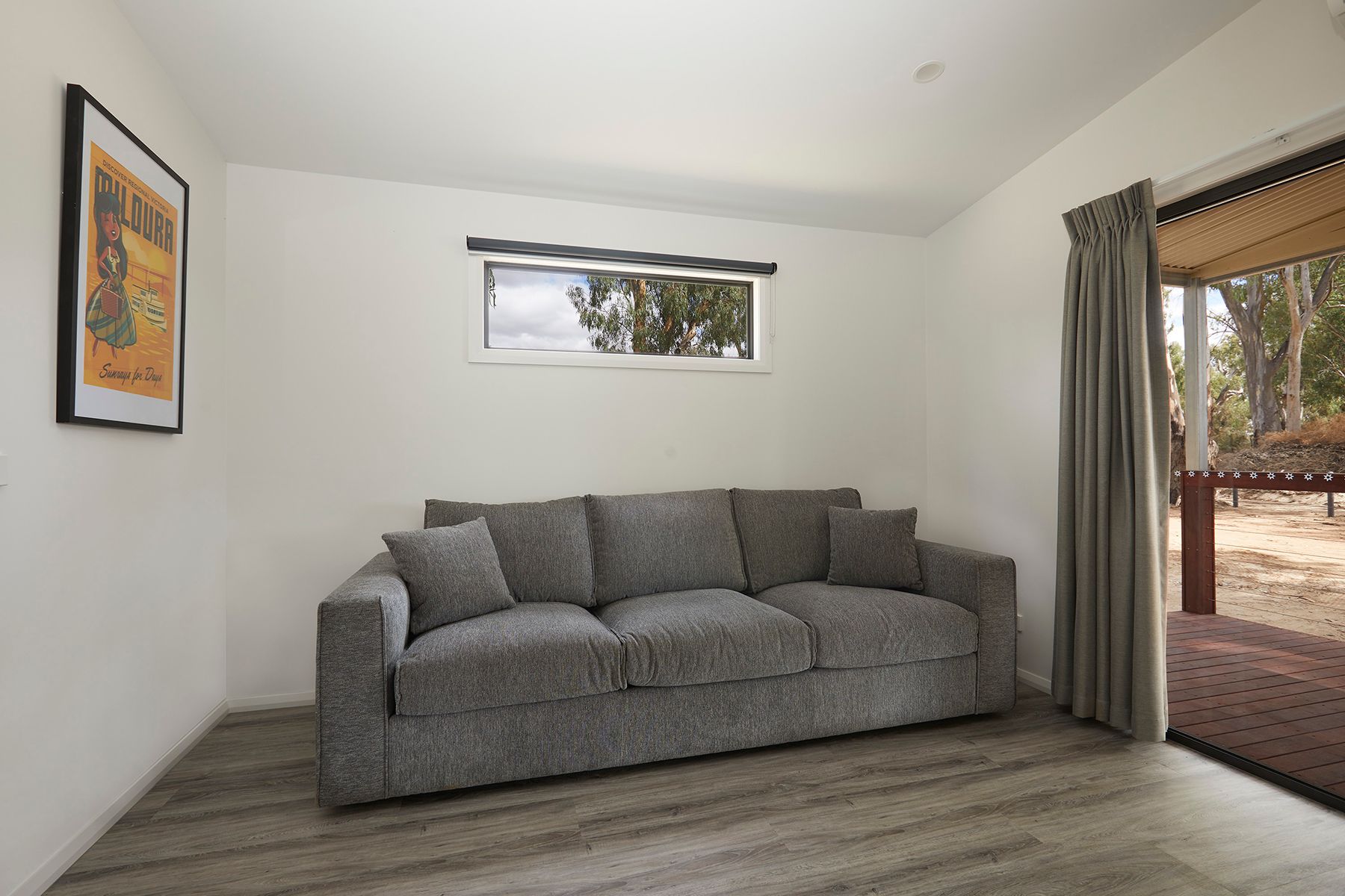 Apex Riverbeach Holiday Park cabin with couch overlooking balcony