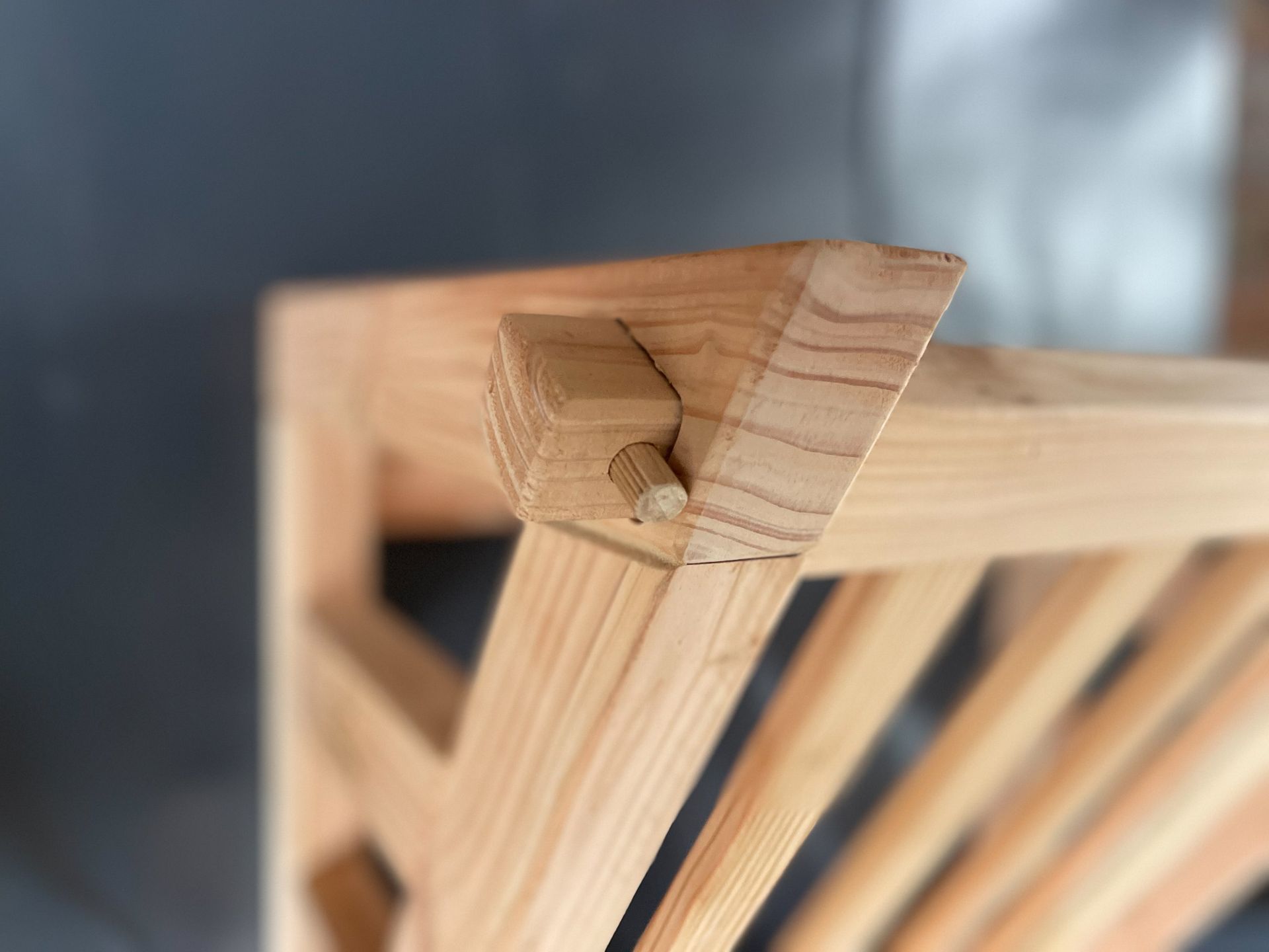 Een close-up van een houten hoekverbinding met een pen-en-gatverbinding, vastgezet met een kleine houten deuvel.