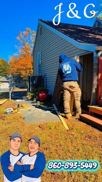 Worker power-washing a house exterior beside autumn trees; J&G logo and phone number at bottom.