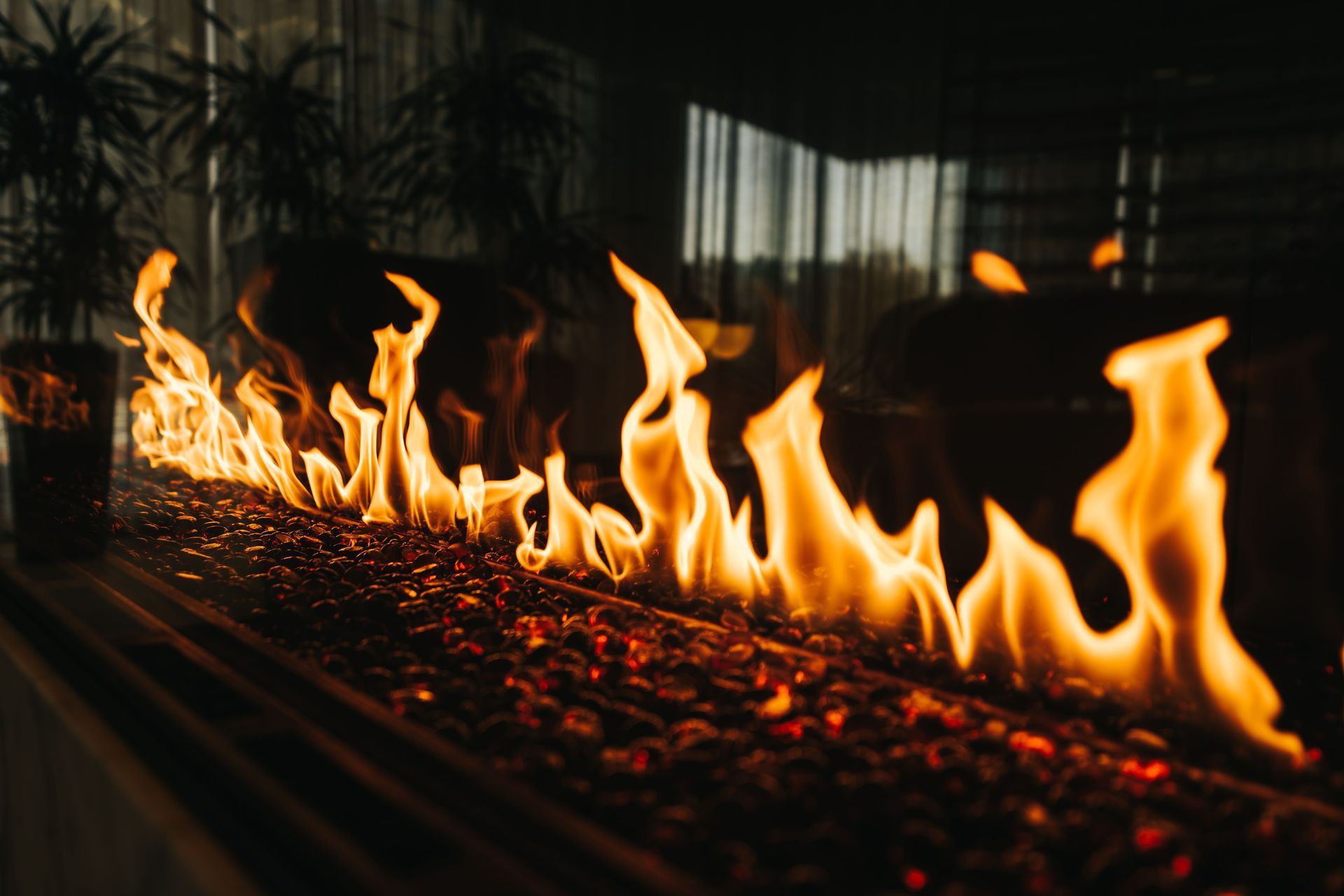 Long line of bright flames burning in a dark fireplace or fire pit