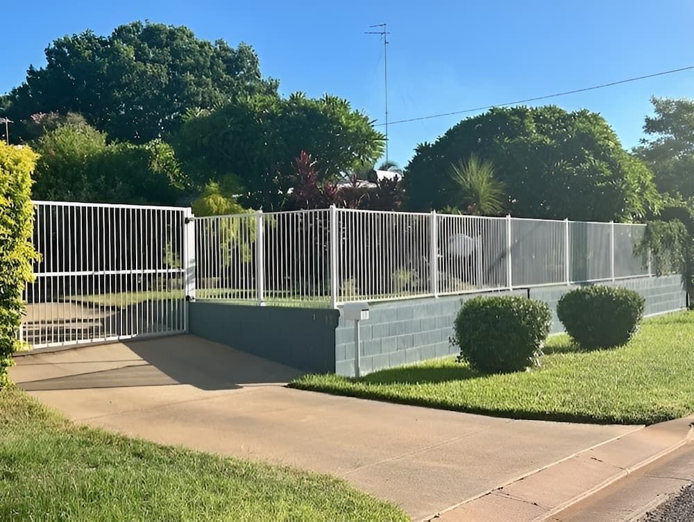 A White Fence Surrounds A Driveway With Trees — PH Davie in Cloncurry, QLD