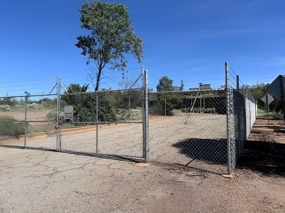 A Chain link Fence with a tree in the Background — PH Davie in Cloncurry, QLD