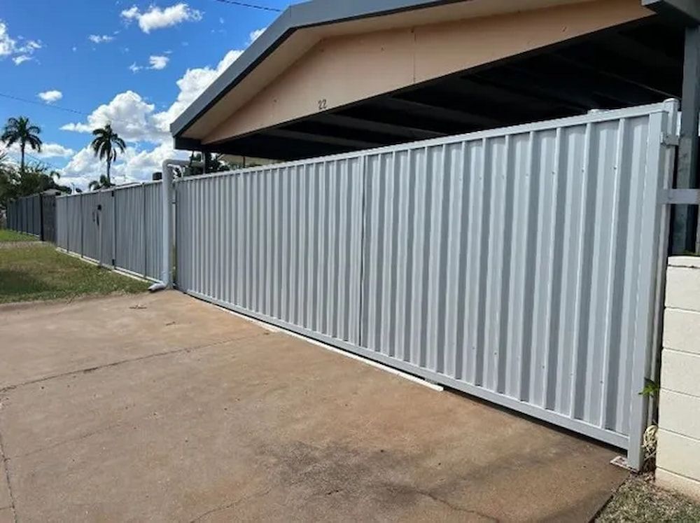 A White Fence Surrounds A Driveway In Front Of A House — PH Davie in Cloncurry, QLD