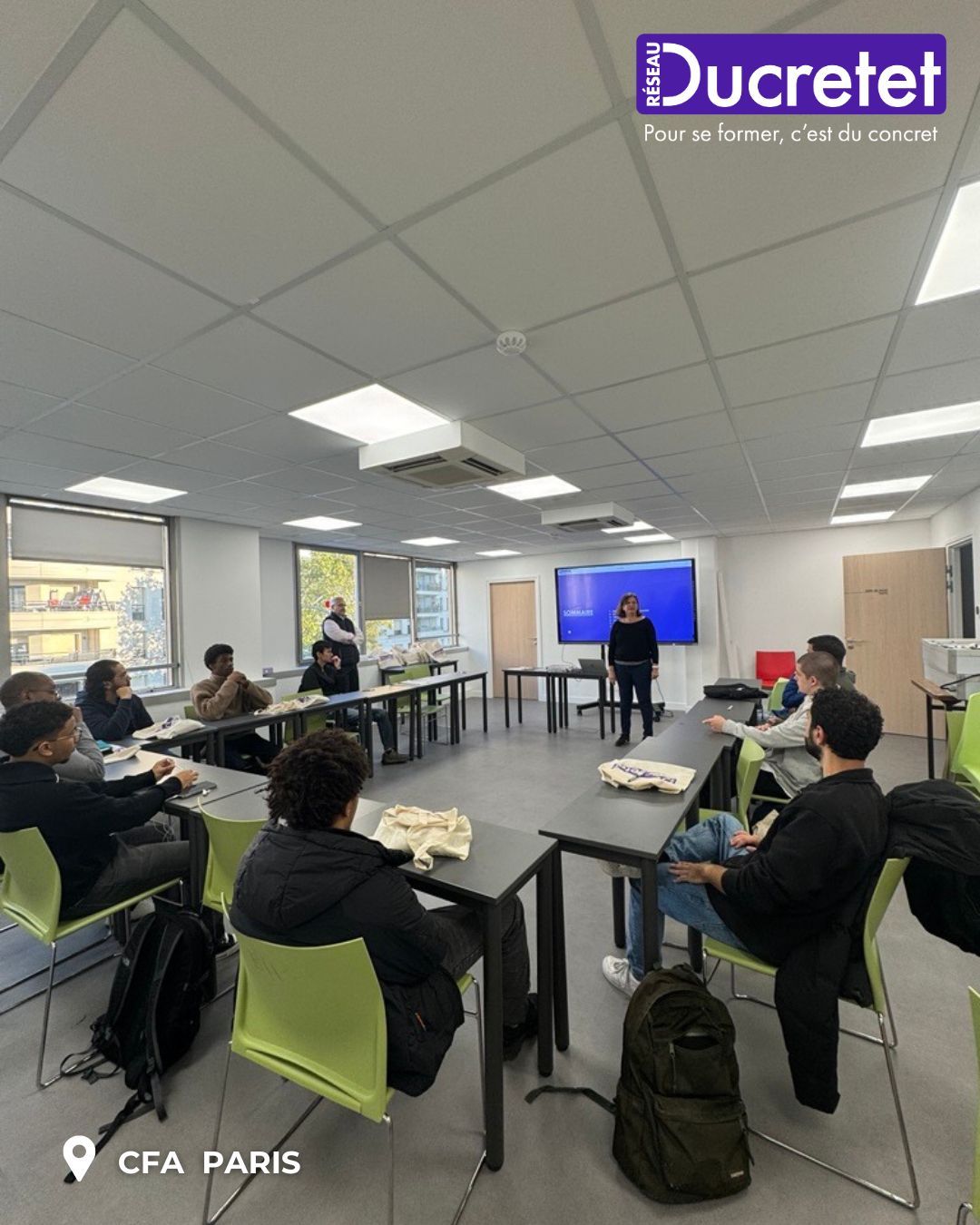 Classroom workshop at CFA Paris with students seated around tables facing a presenter and screen
