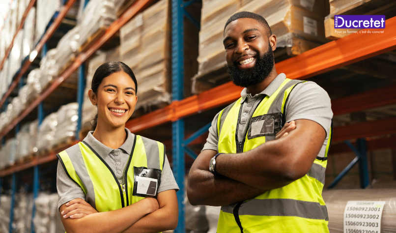 Two warehouse workers in high-visibility vests stand with arms crossed in a stocked aisle.