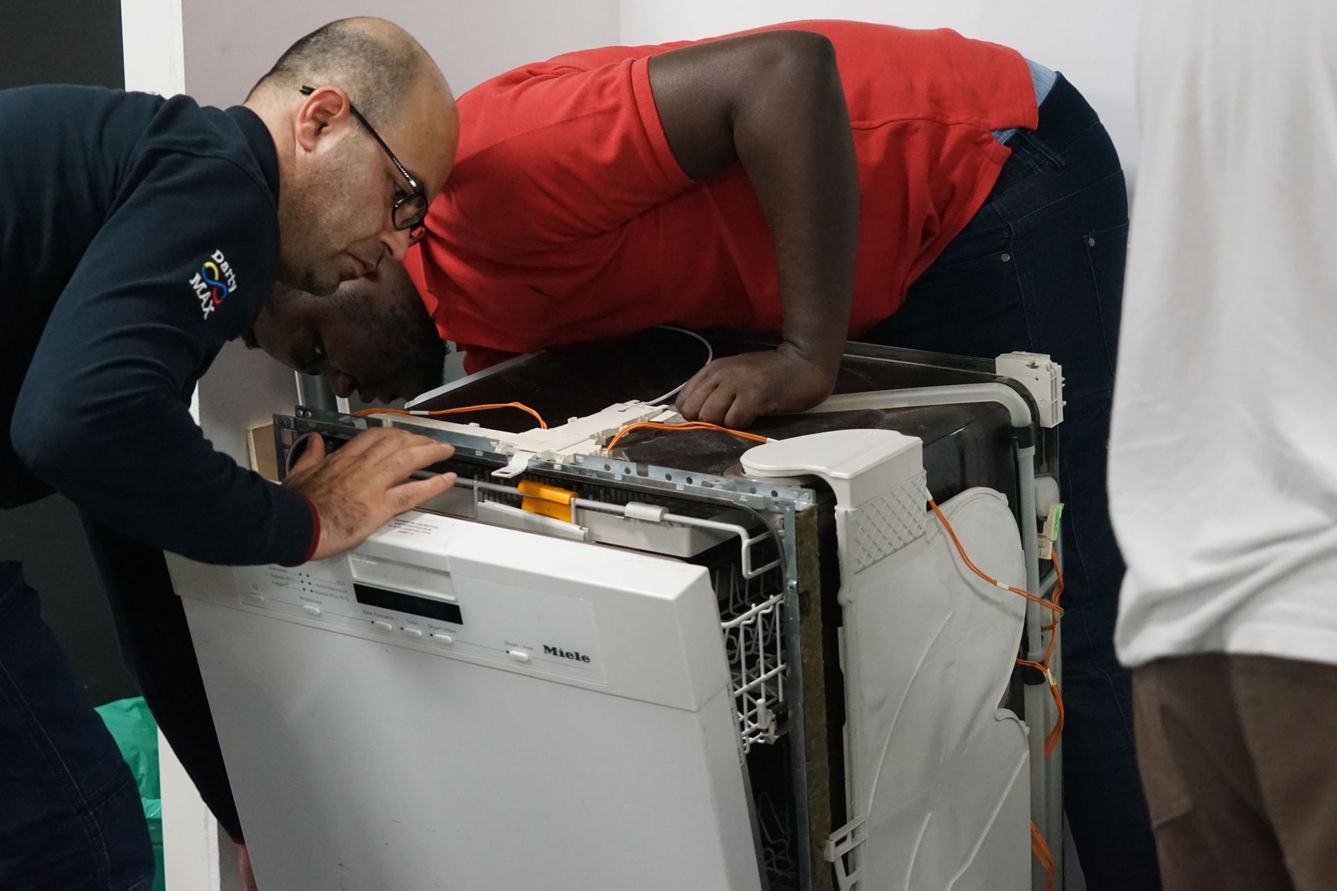 Deux apprenants du CFA Ducretet en train de réparer un gros électroménager 