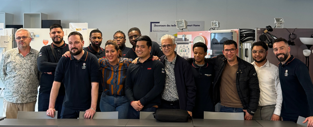 Groupe de personnes posant souriant dans le showroom connecté de Ducretet