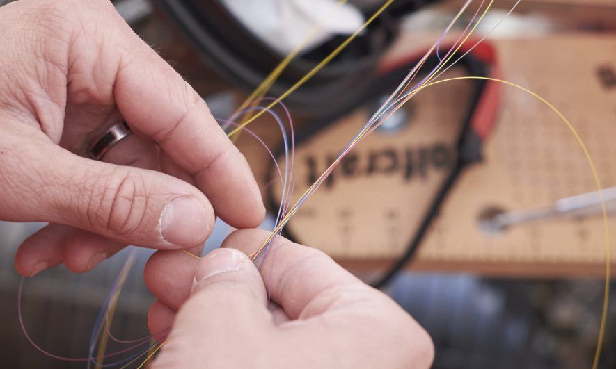 Une personne en train de manipuler des câble dans la Formation Fibre Optique