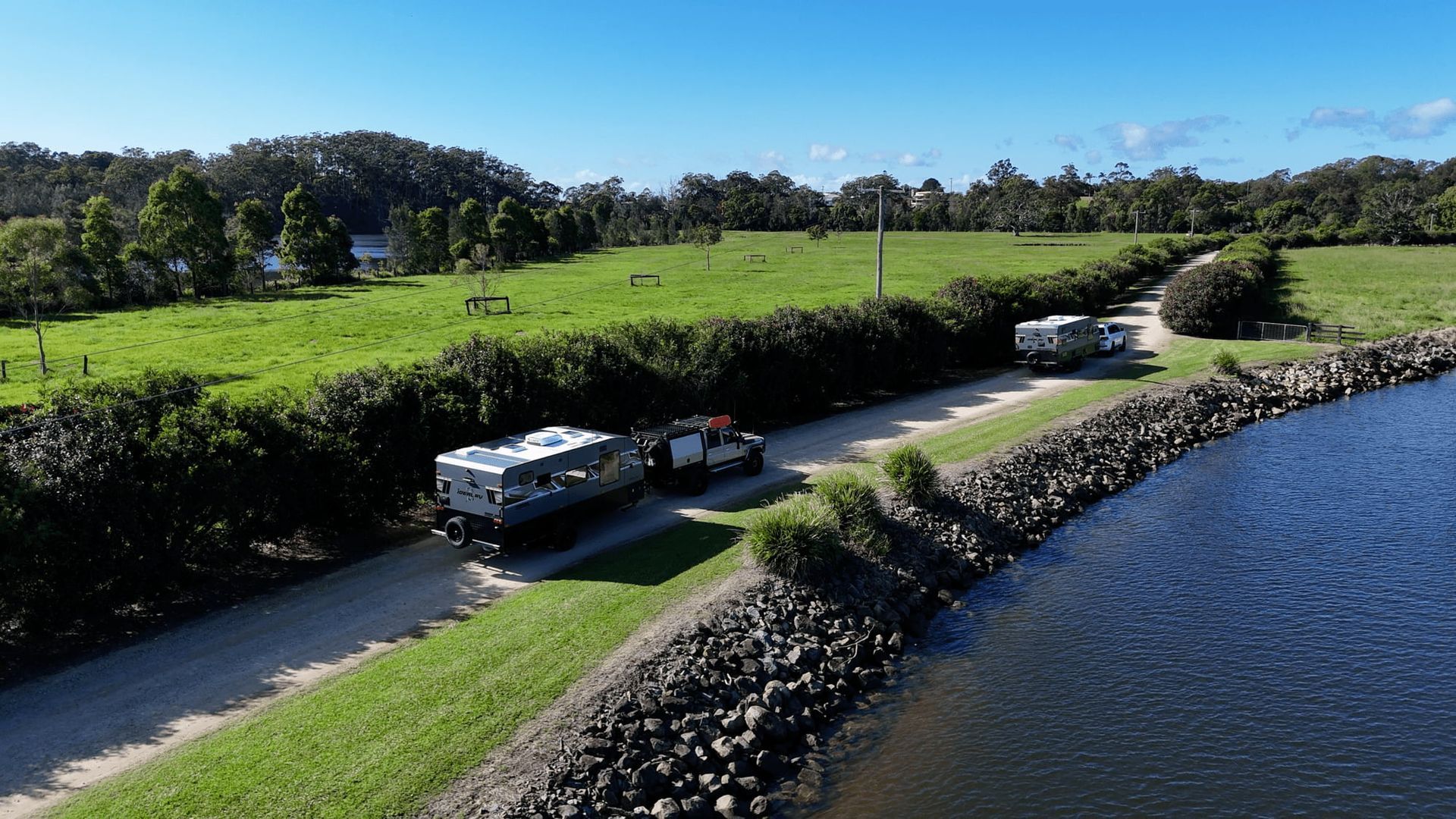 A white Landcrusier is towing a trailer on the beach - Hanson Caravans in Coffs Harbour