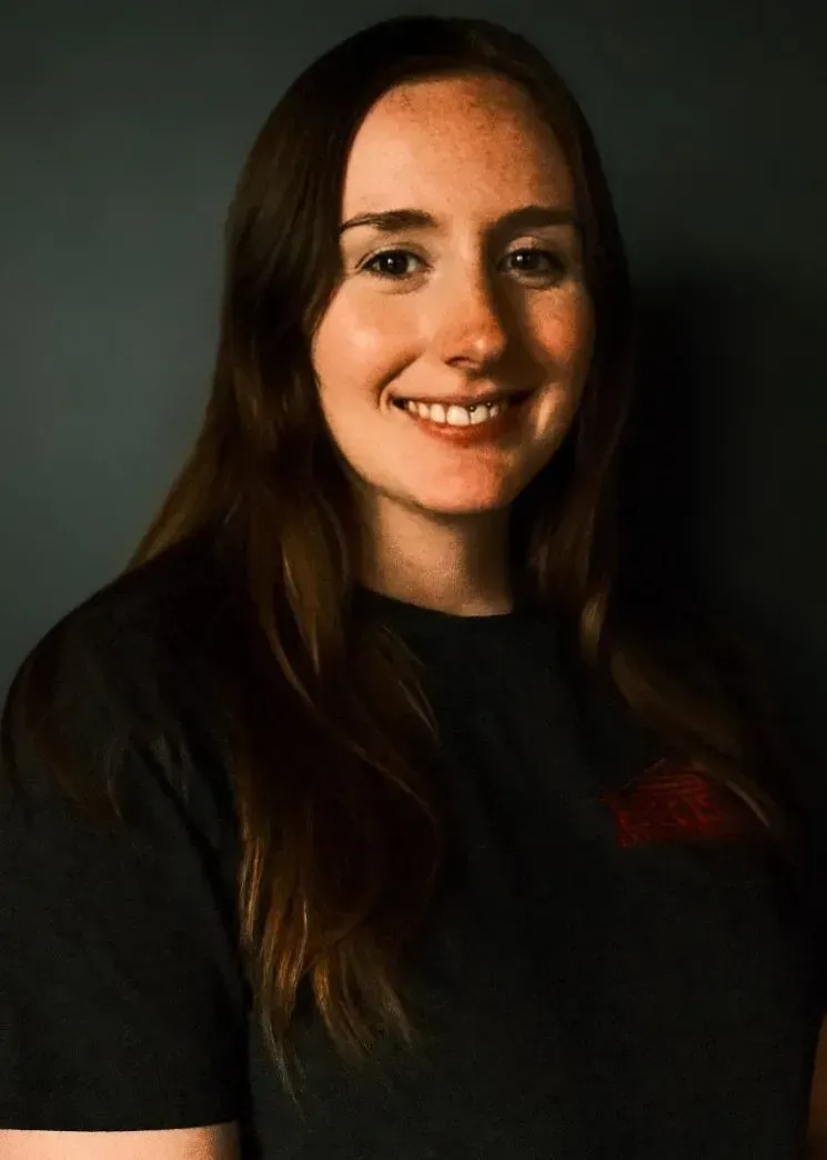 A woman in a black shirt is smiling for the camera.