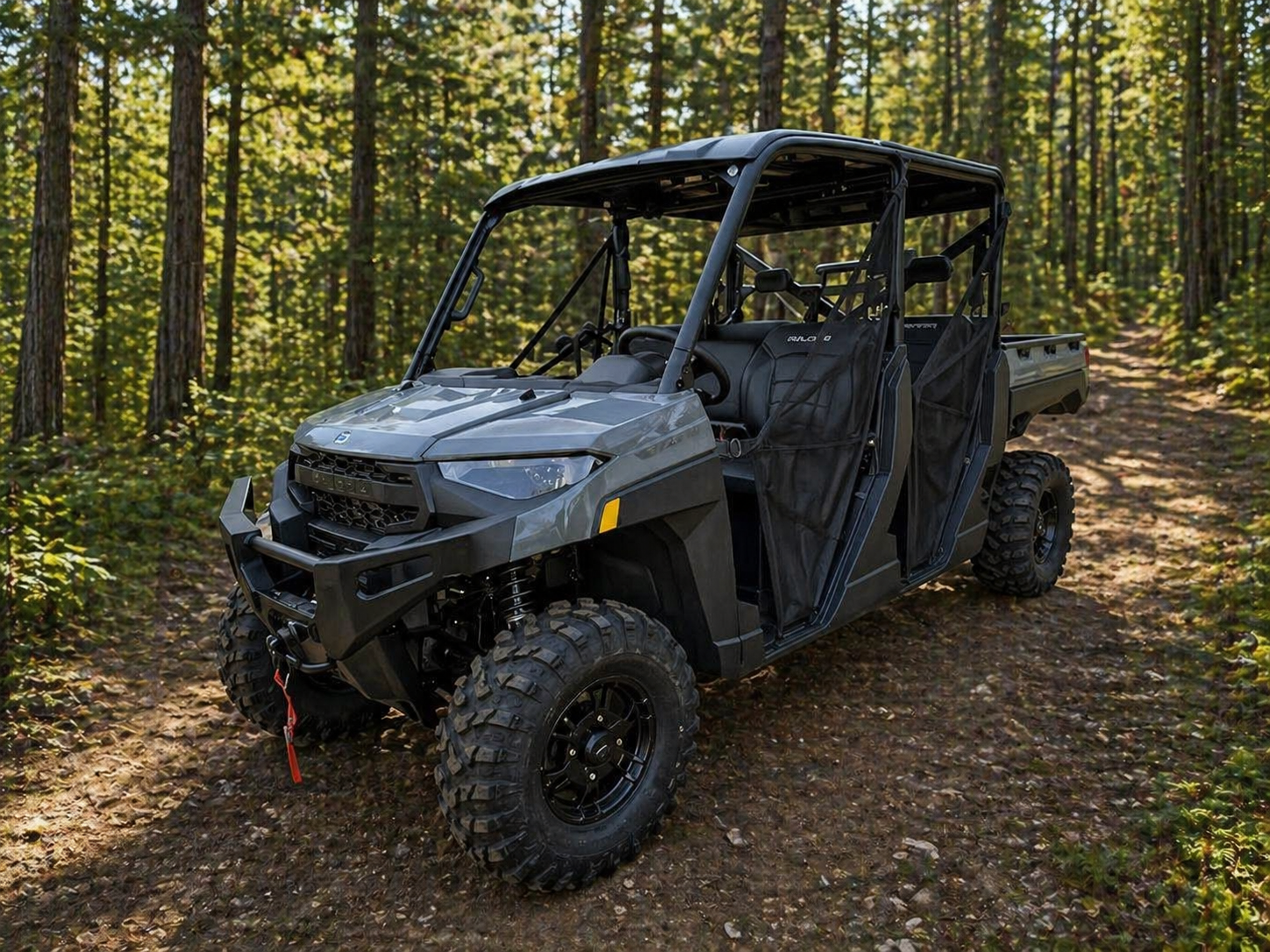 Black side-by-side UTV parked on gravel beside a wooden fence, with two empty rows of seats.