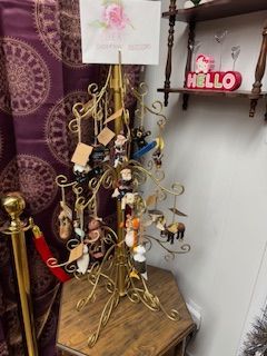 Gold display stand with ornaments for sale. Red velvet rope and