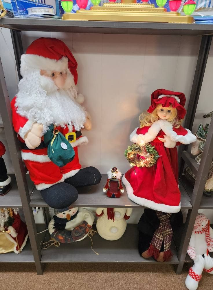 Shelf display with Santa, girl in red dress, nutcracker, and other Christmas decorations.