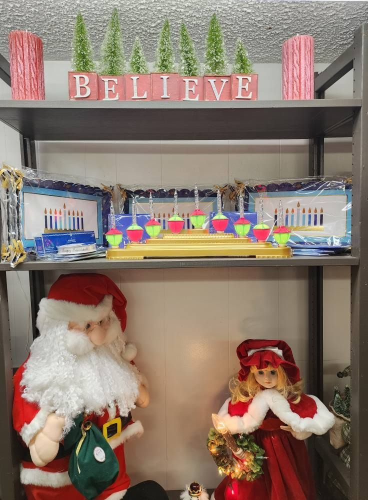 Shelves with Christmas decorations, including Santa, a doll, and a 