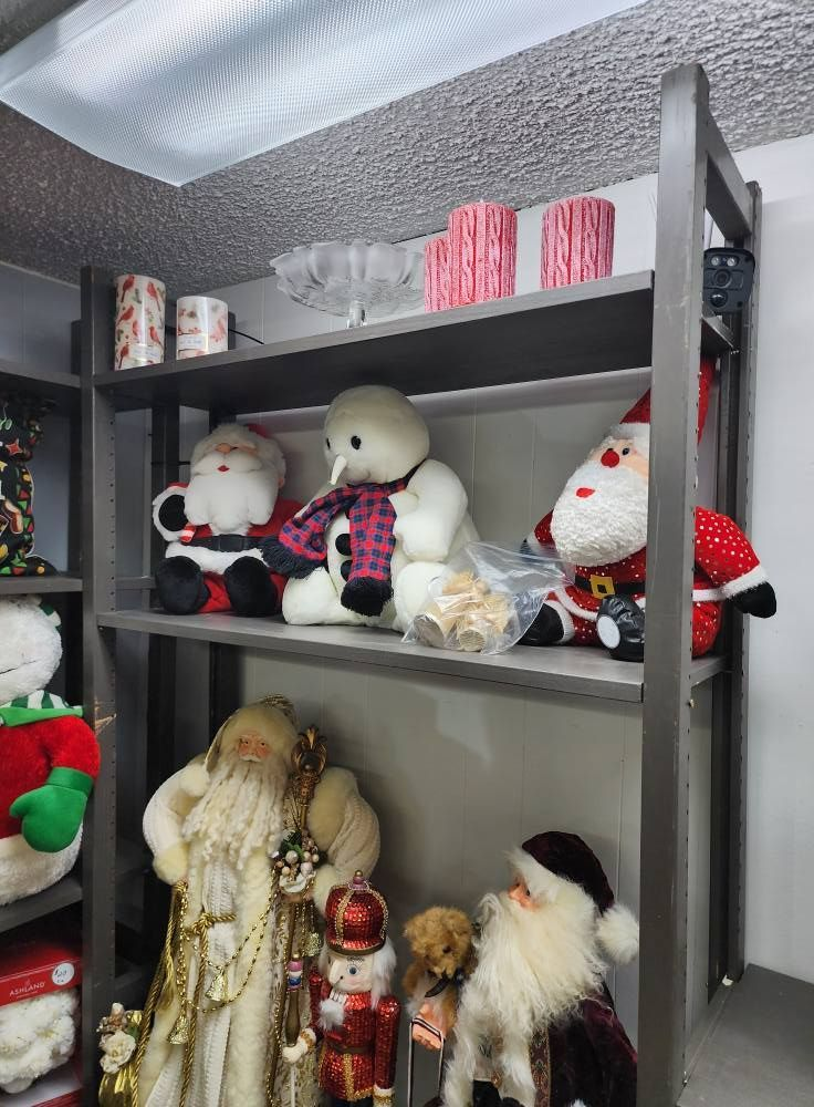 Shelves holding Christmas decorations: Santa dolls, snowman, candles, and a nutcracker.