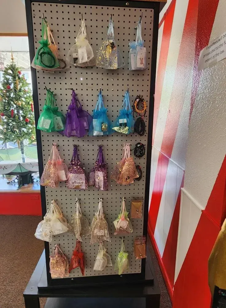 Display of colorful cone-shaped gifts on a pegboard; a Christmas tree is visible in the background.