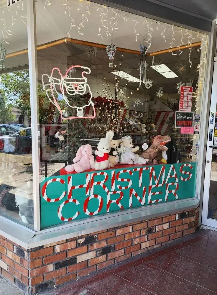Christmas Corner storefront with Santa neon sign, plush toys, and holiday decor.