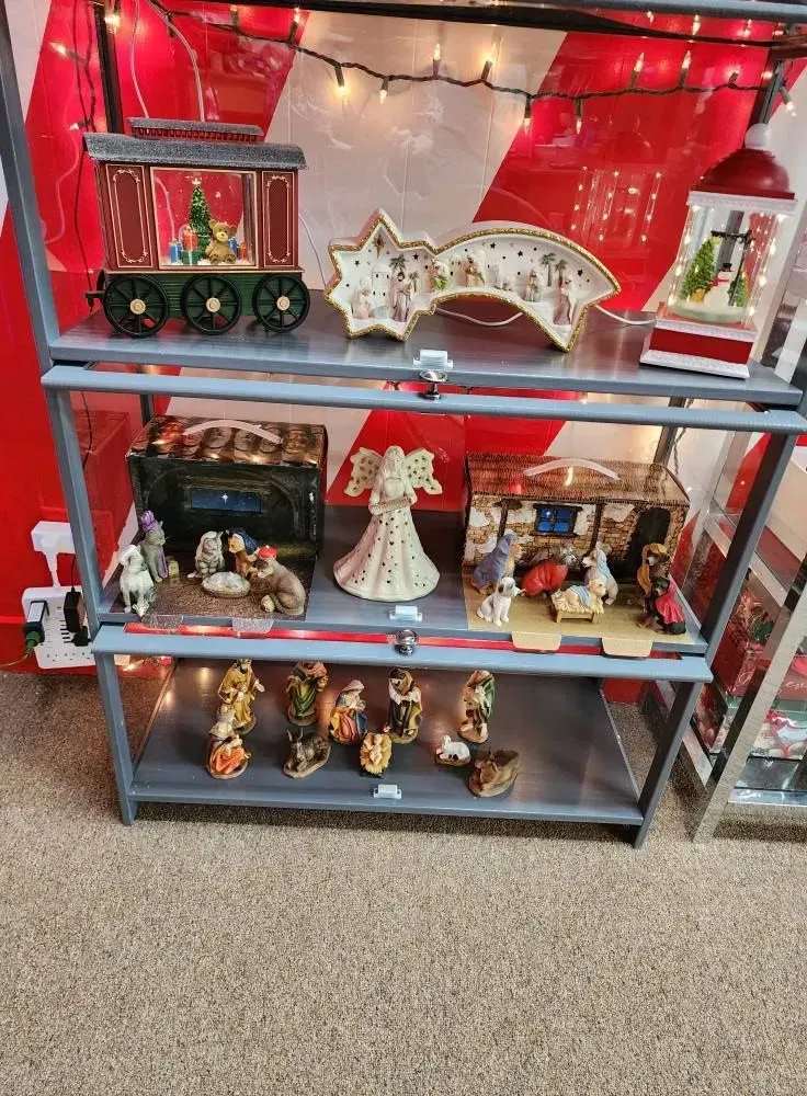 Christmas display: shelves with holiday decorations, including a train, angels, and nativity scenes.