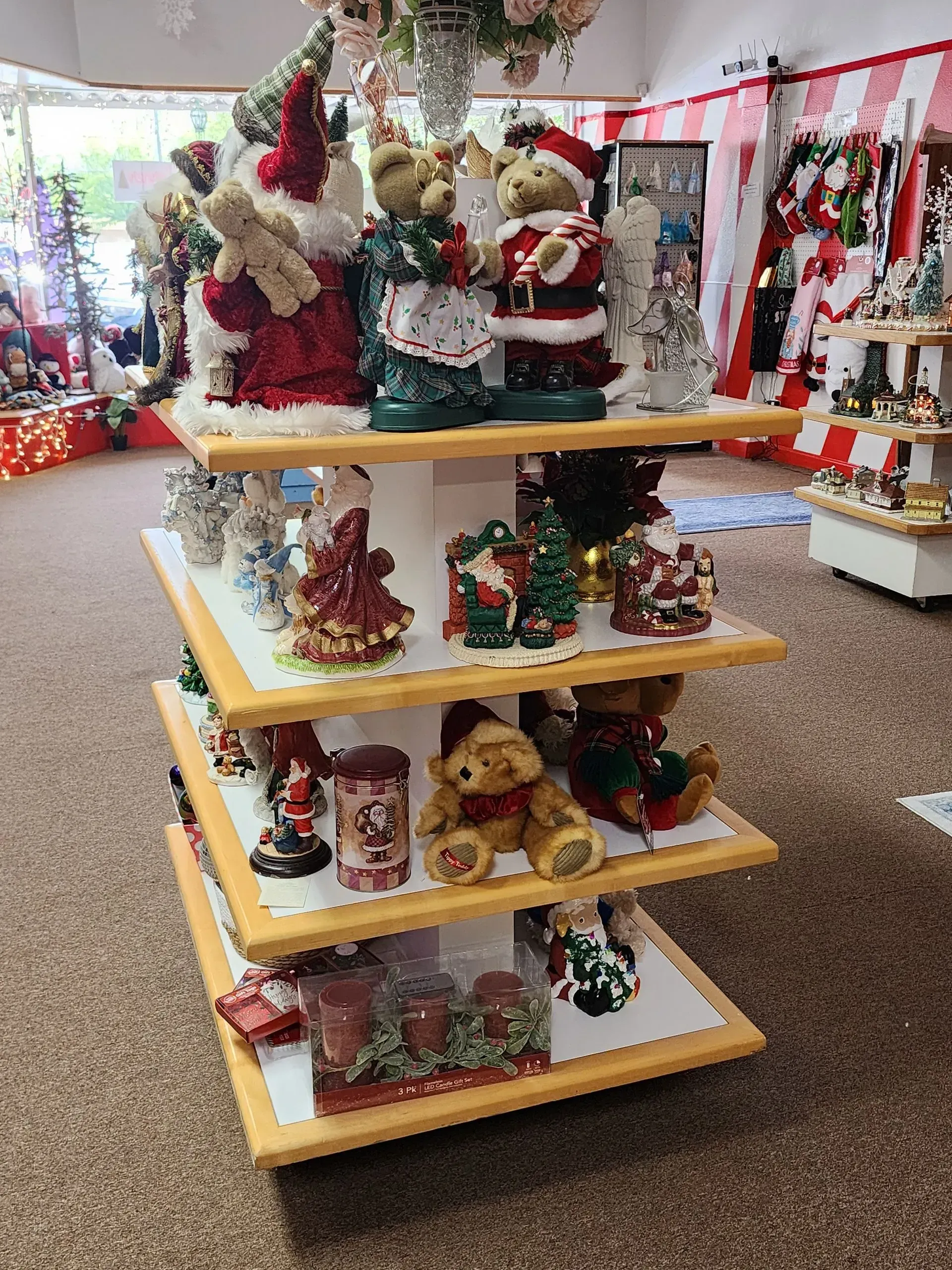 Shelving unit displaying various Christmas-themed figurines and decorations inside a store.