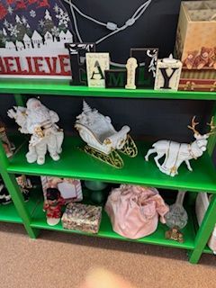 Green shelves displaying Christmas decorations: Santa, sleigh, reindeer, and