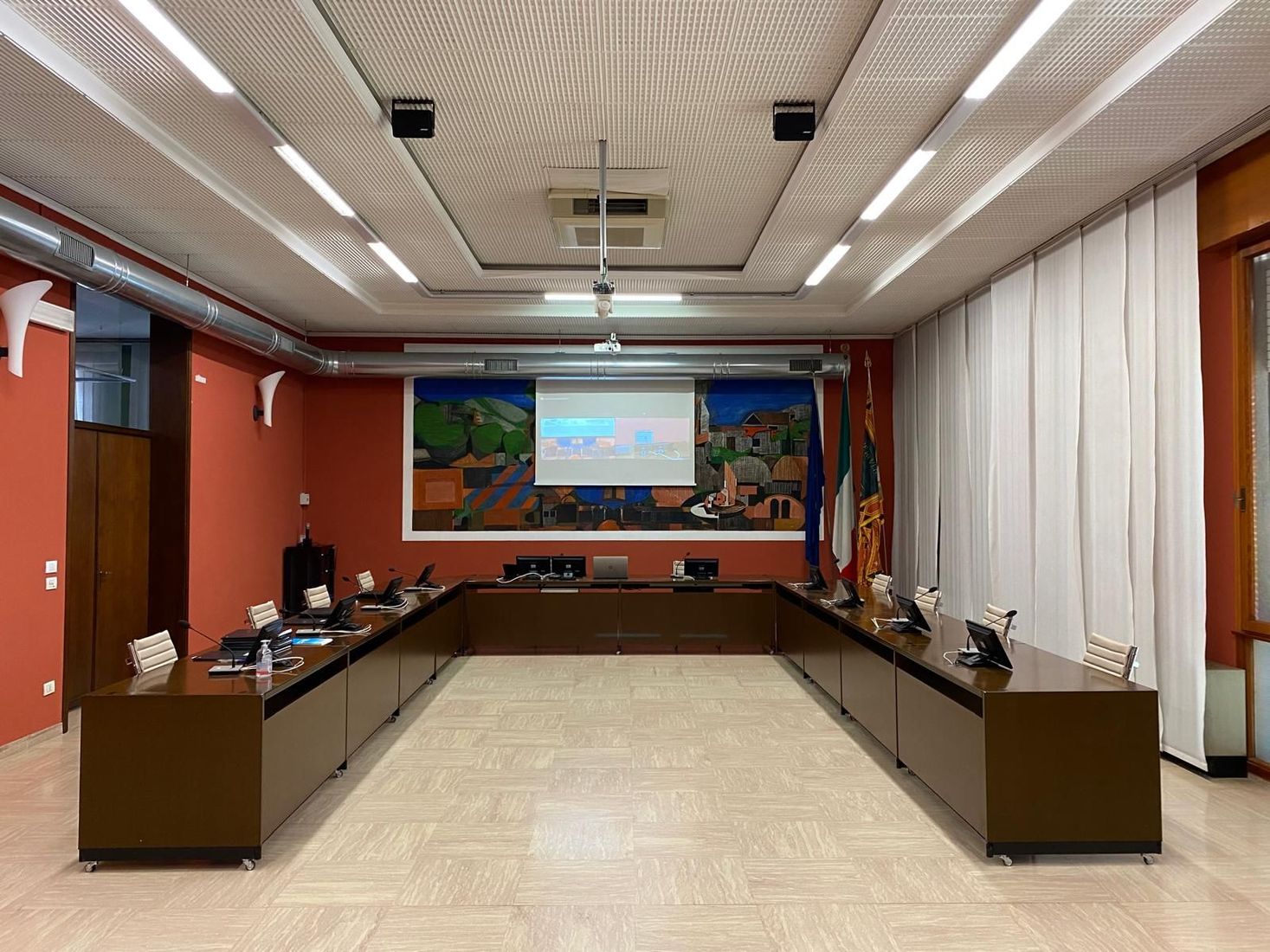 Grande videowall curvo che mostra una vista desktop e aerea di un edificio, in una stanza moderna.