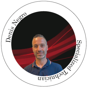 Denis Negro, tecnico specializzato. Ritratto in un cerchio rosso e nero. Sorridente con una polo blu.