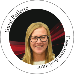 Giusi Falletto, assistente di direzione, sorridente, con gli occhiali. Top bianco, sfondo rosso e nero.