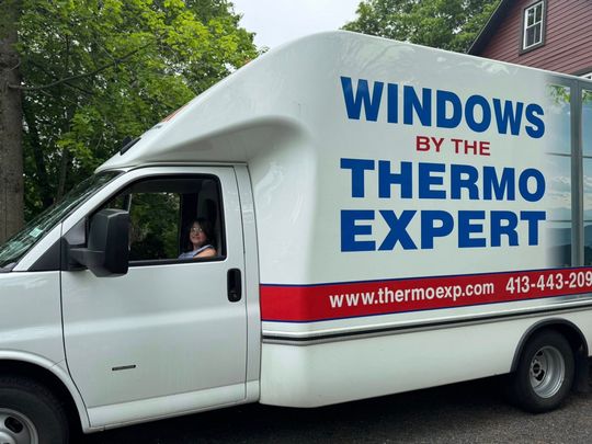 White Thermo Expert window-service truck with blue and red lettering, driver visible in the cab.