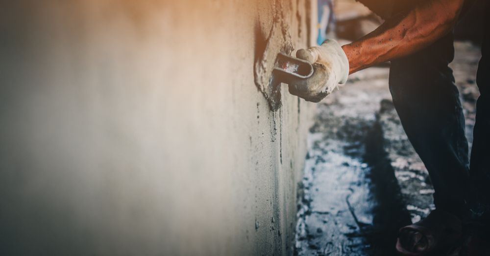 A Man is Plastering a Wall With a Trowel — Barrington Coast Contracting in Bulahdelah, NSW