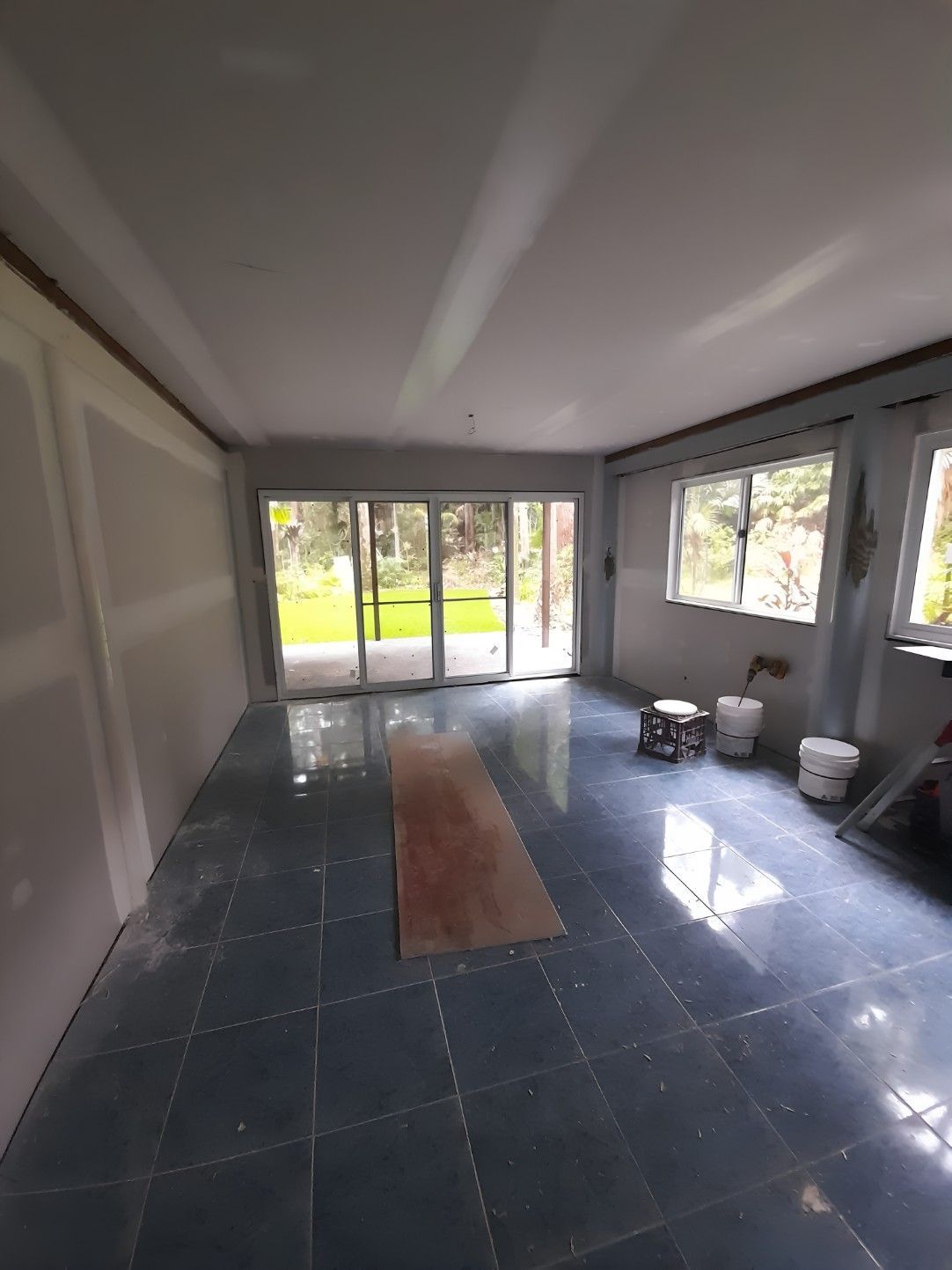 A Person is Plastering a Wall With a Trowel — Barrington Coast Contracting in Gloucester, NSW