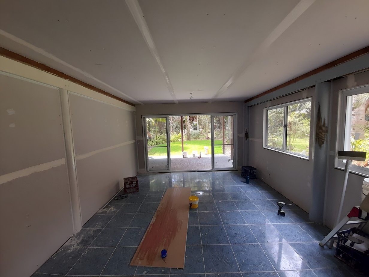A Person is Plastering a Ceiling With a Spatula — Barrington Coast Contracting in Gloucester, NSW