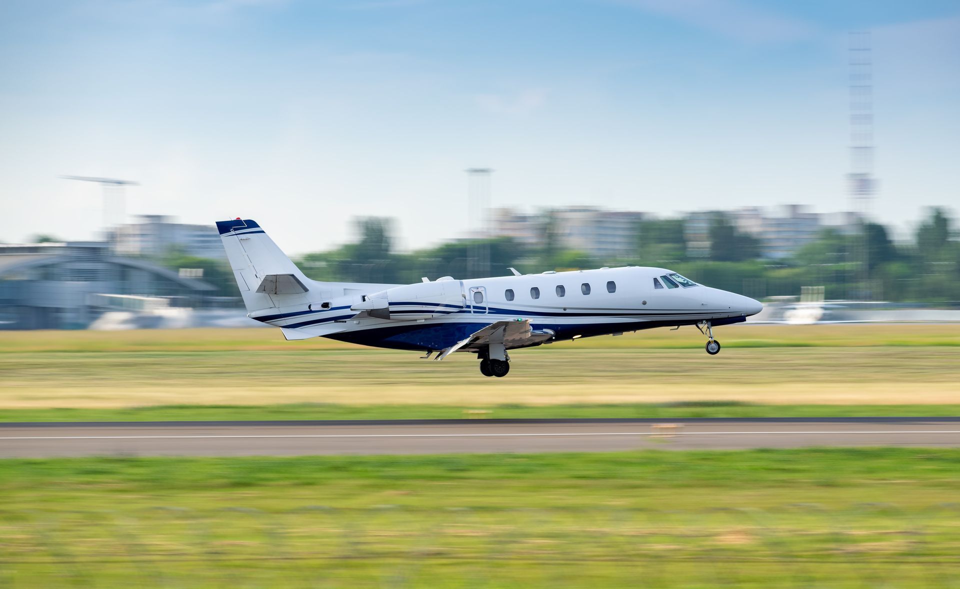 White private jet landing on a runway with blurred background White private jet landing on a runway with blurred background