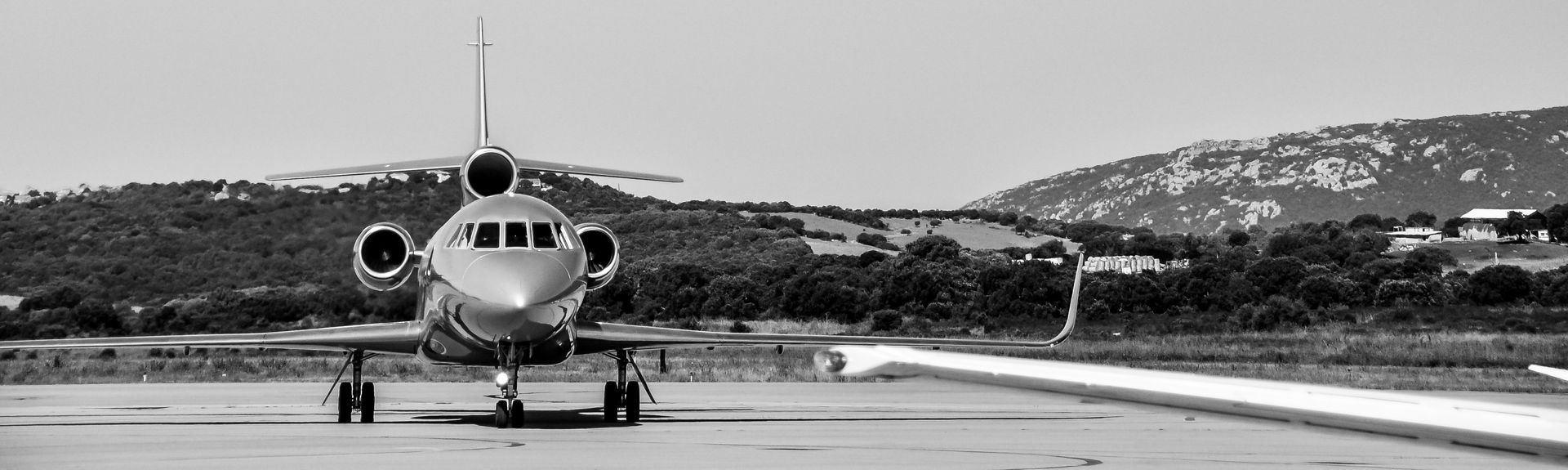 Small airplane on a runway, facing forward with mountains in the background. Small airplane on a runway, facing forward with mountains in the background.