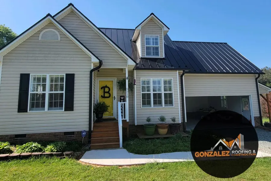 A white house with a black roof and a yellow door