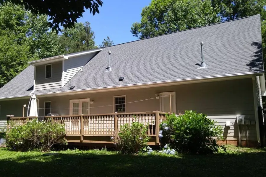 A large house with a gray roof and a large deck