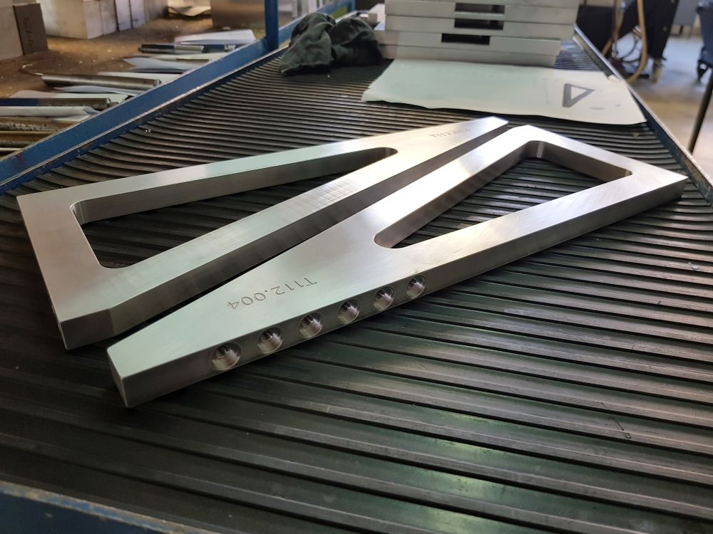 Two Pieces Of Metal Are Sitting On A Conveyor Belt — D.E.M Solutions Pty Ltd In Caboolture, QLD