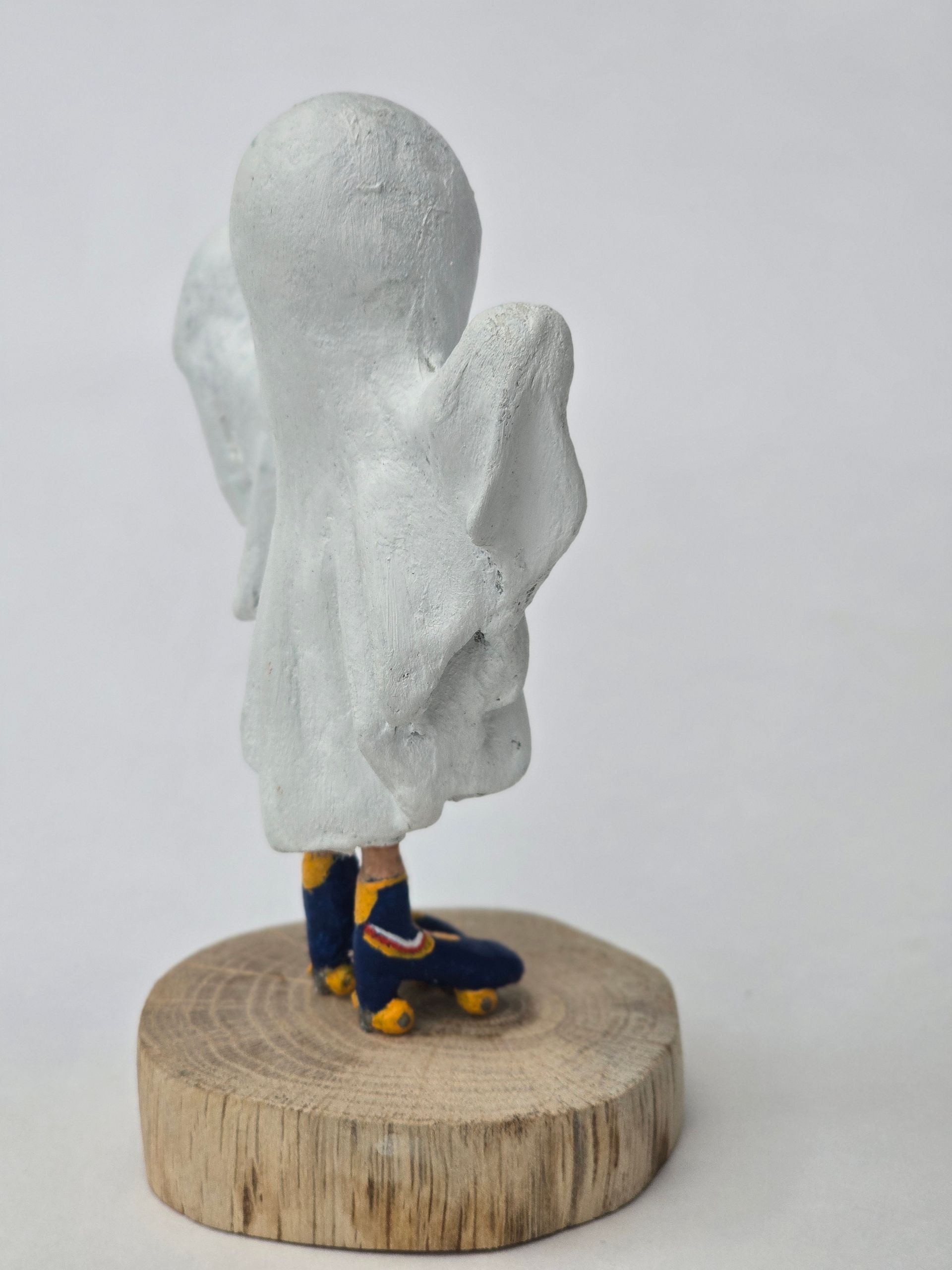 Achteraanzicht van een spookachtige figuur in blauwe laarzen op een houten sokkel.