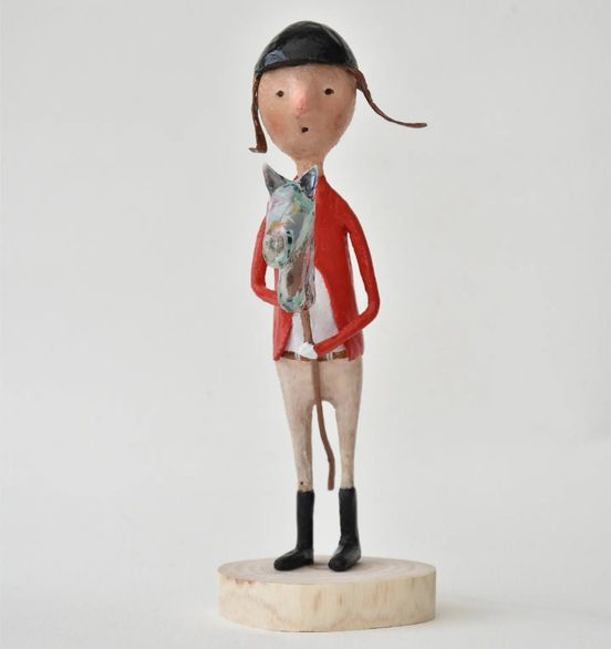 Een standbeeld van een man in een rood jasje die een paard vasthoudt