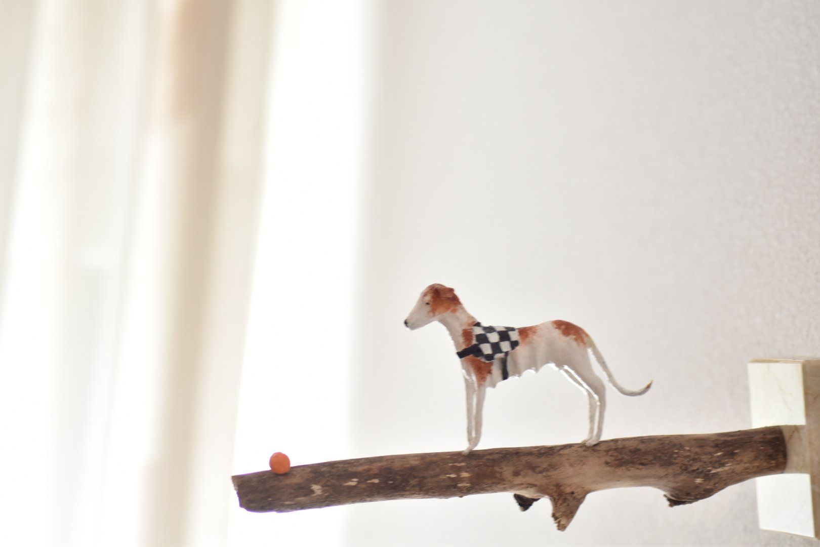 Een beeldje van een hond die op een tak staat