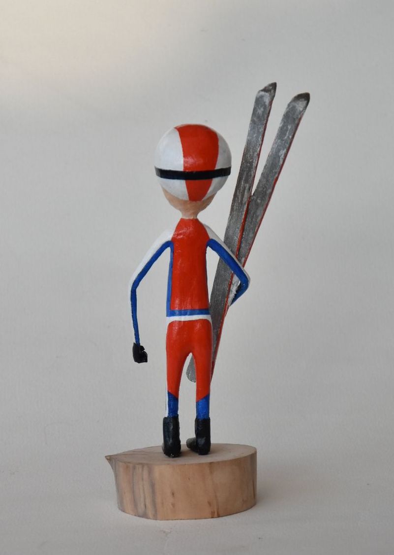 Een rood-wit-blauw beeldje van een persoon die ski's vasthoudt