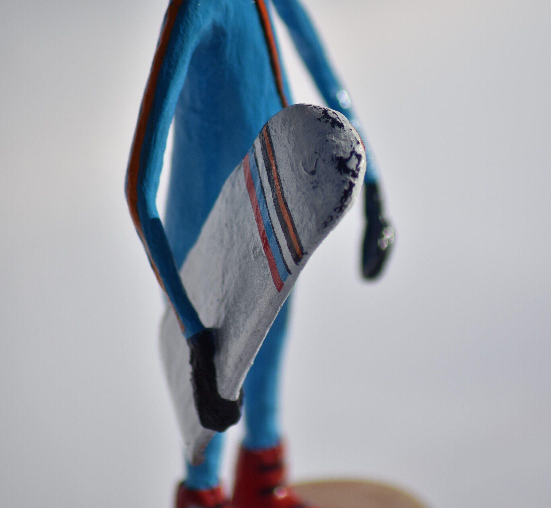 Een standbeeld van een persoon in een blauw pak die een snowboard vasthoudt