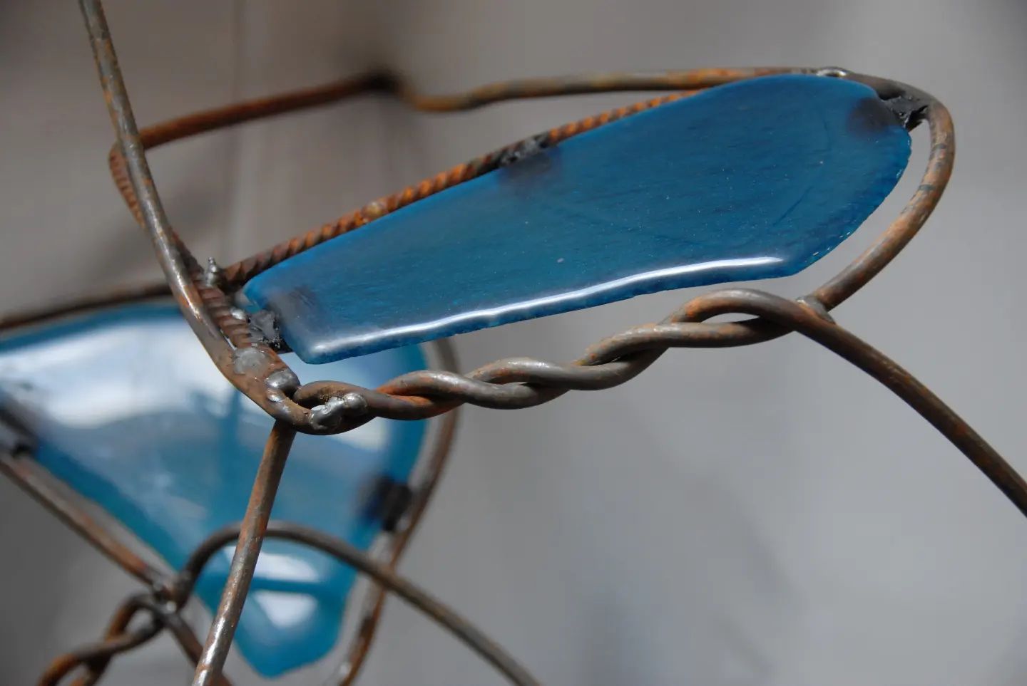 Een close-up van een draadsculptuur met een blauw object erin