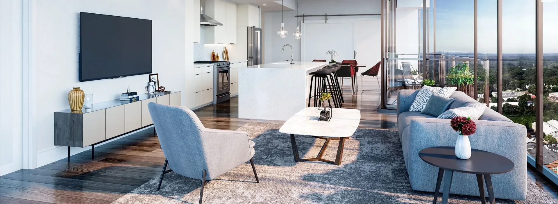 Modern living room with kitchen and balcony overlooking a city, featuring a grey sofa, armchair, marble coffee table, and a large TV.