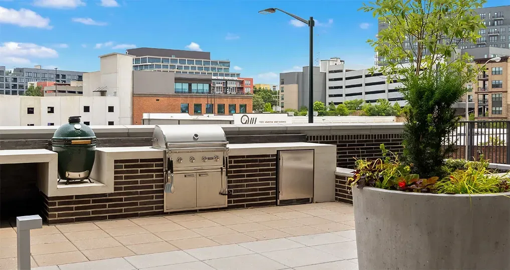 Outdoor kitchen with grill and Big Green Egg on a rooftop patio with city views