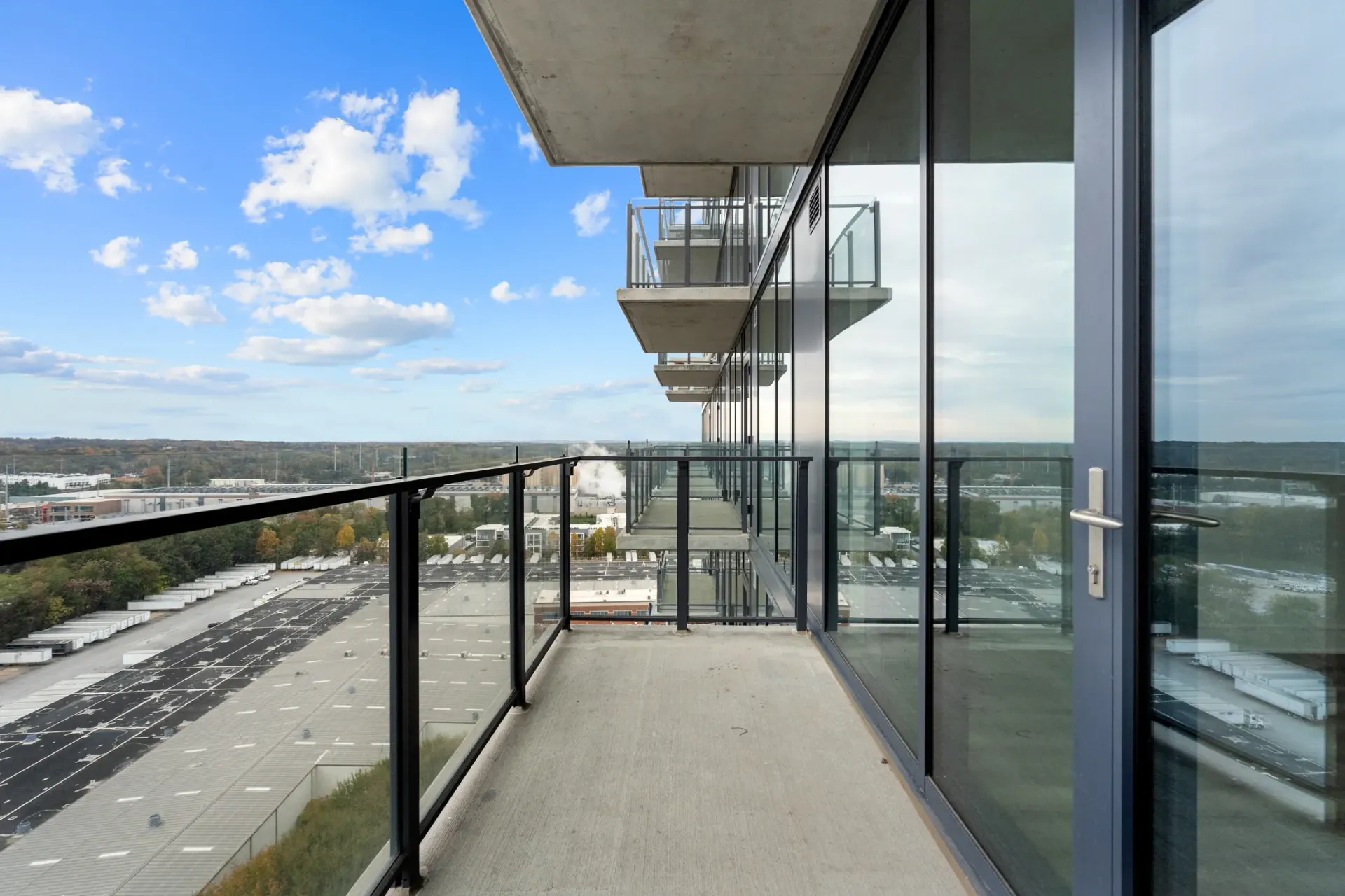 Balcony view from a high-rise apartment overlooking a city.