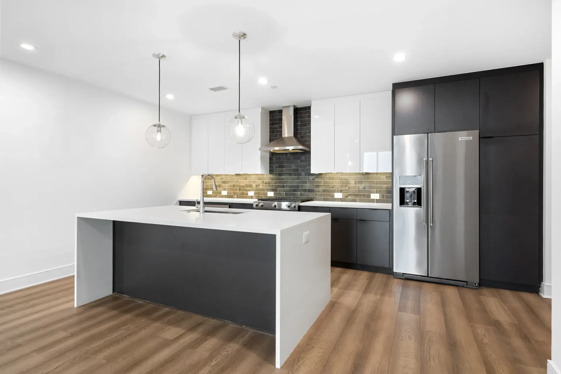 Modern kitchen with a large island and stainless steel appliances.