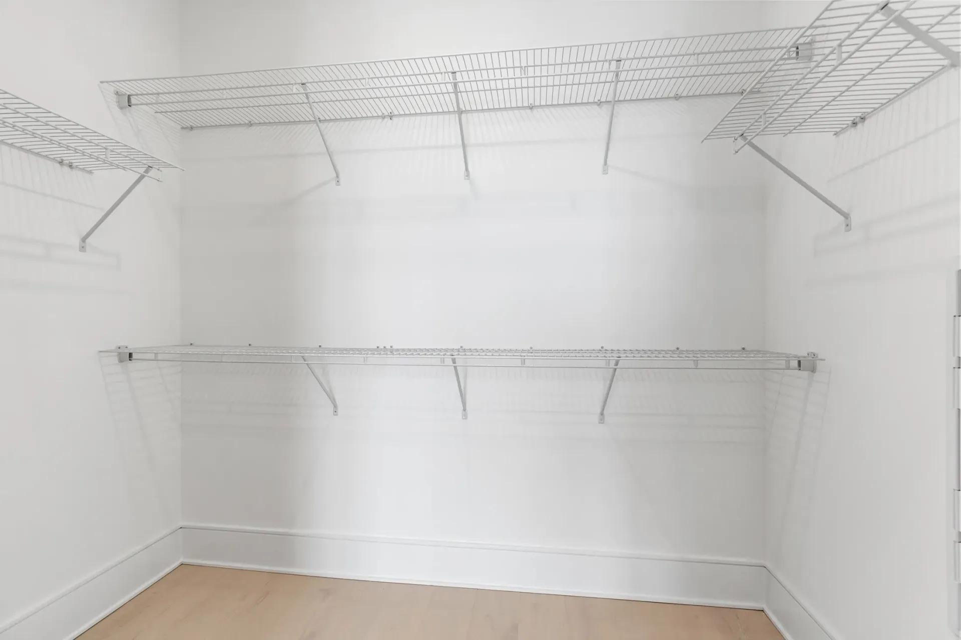 Empty walk-in closet with wire shelving.